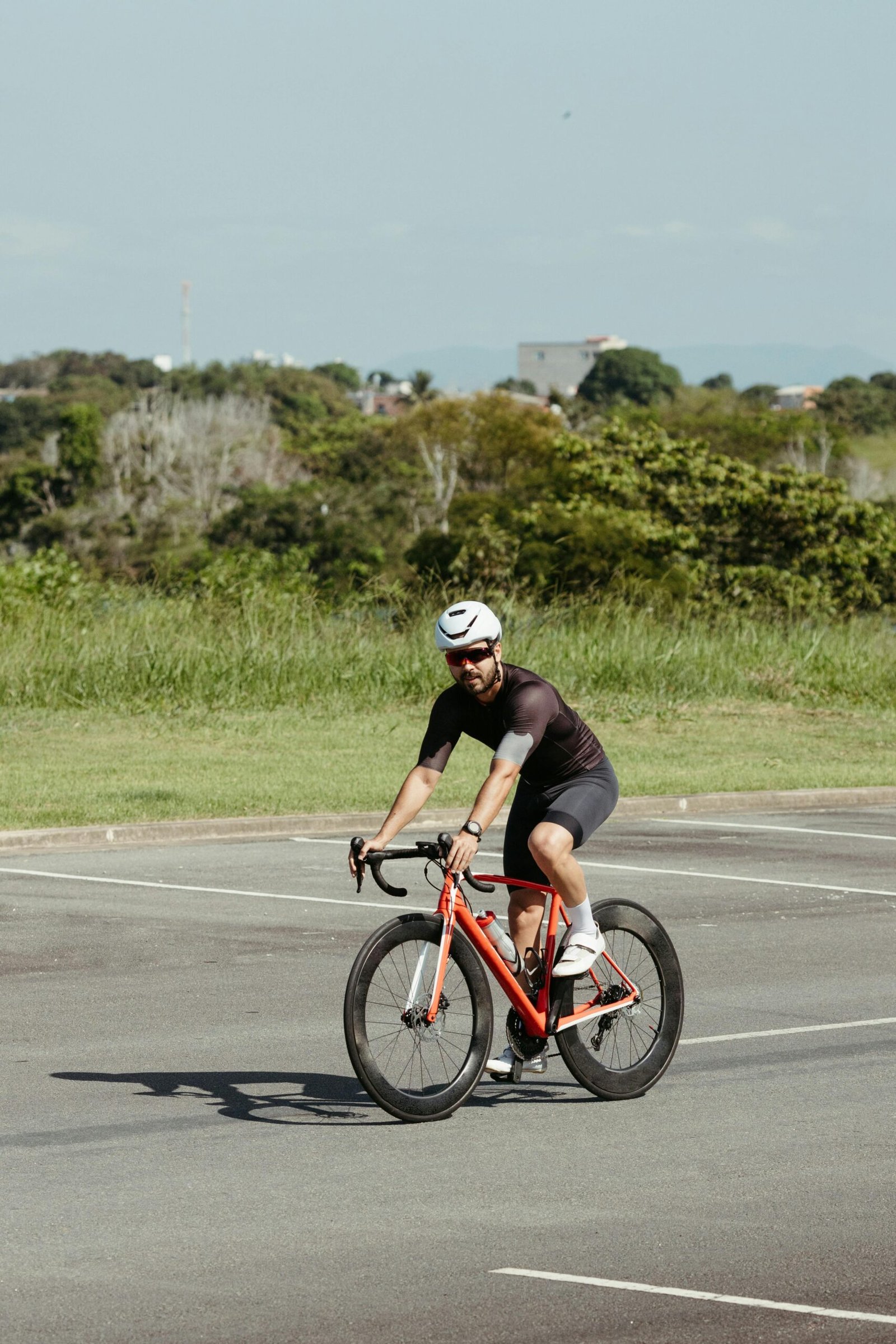 Adult male cyclist in helmet enjoying a ride on his bike in a sunny outdoor setting.